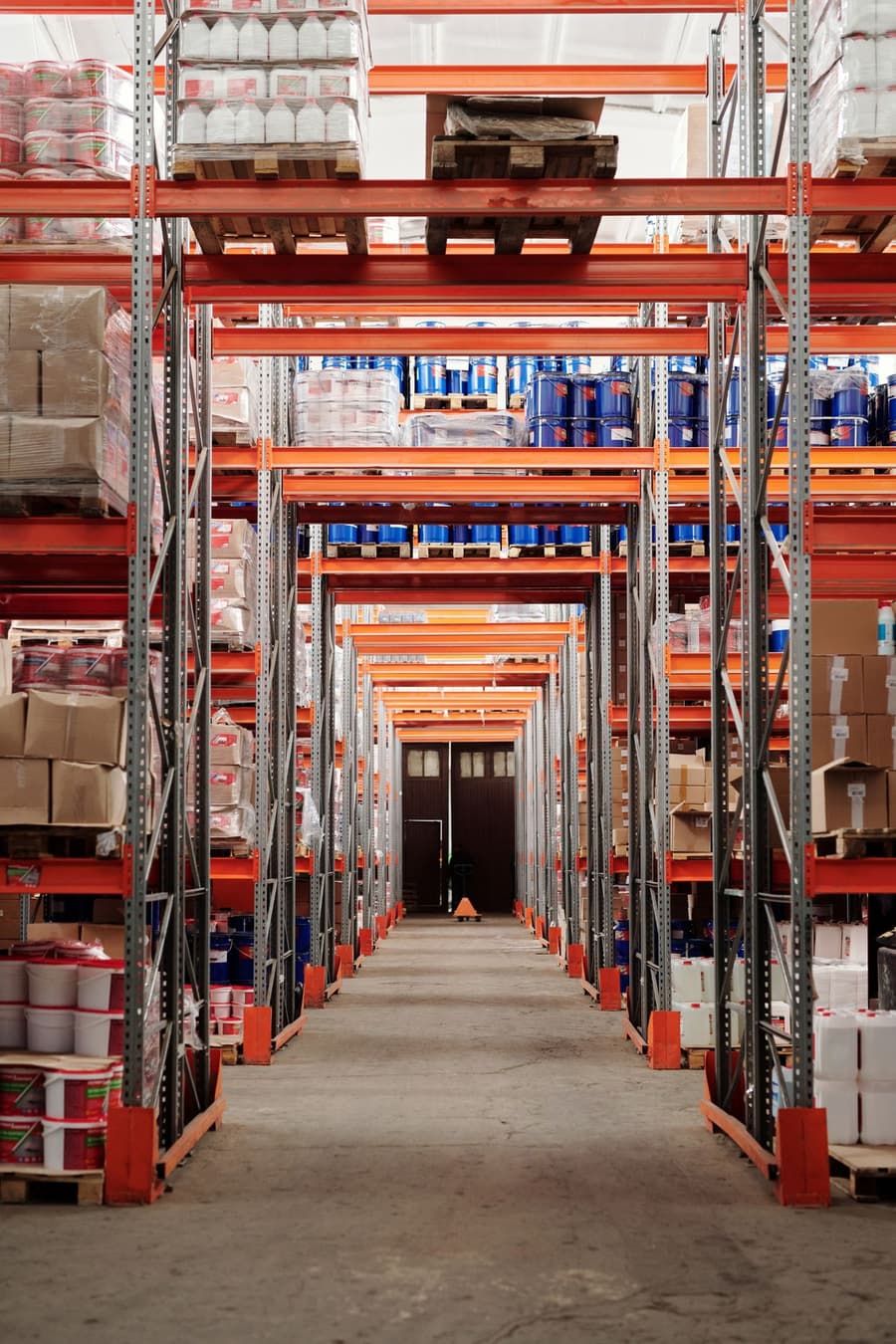 Interior de um armazém com estantes, mercadorias e equipamento logístico