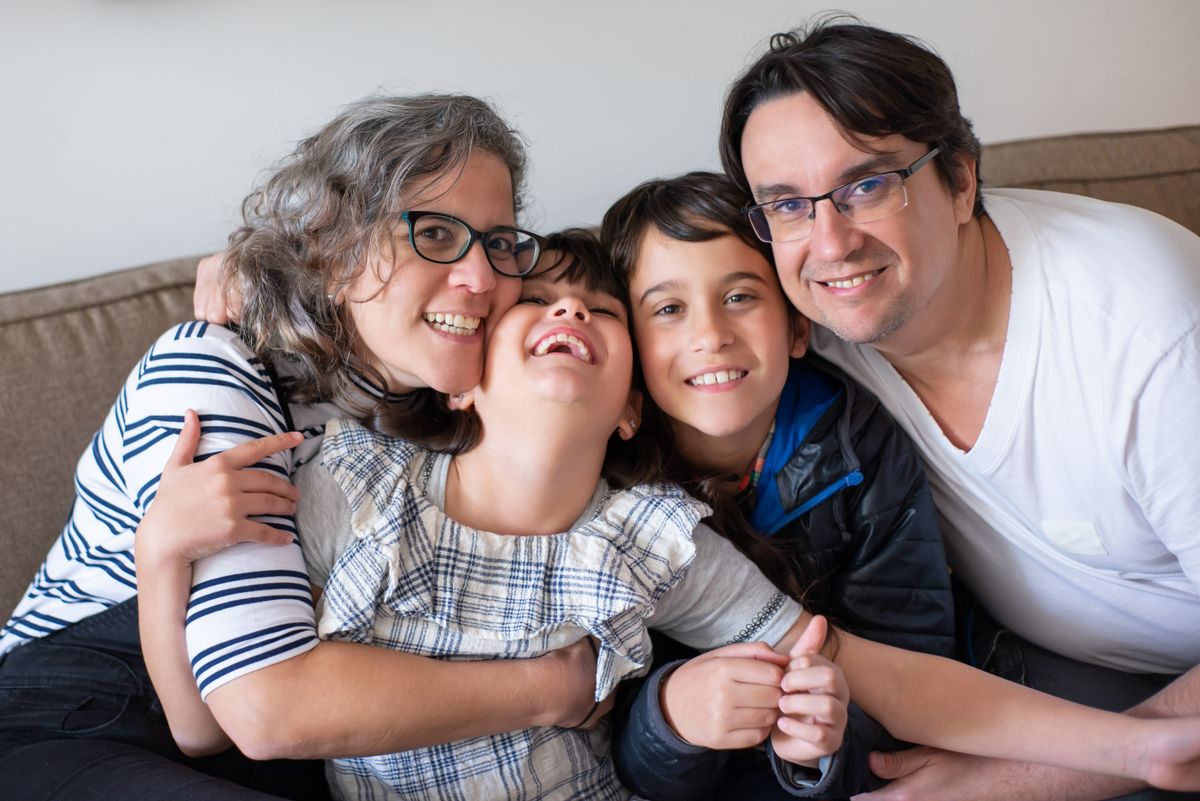 Pais e filhos juntos num momento de convívio em casa